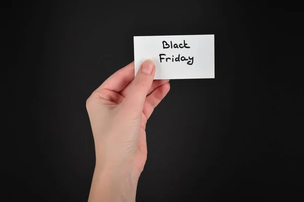 Black friday text on a card in woman  on a black background. — Stock Photo, Image