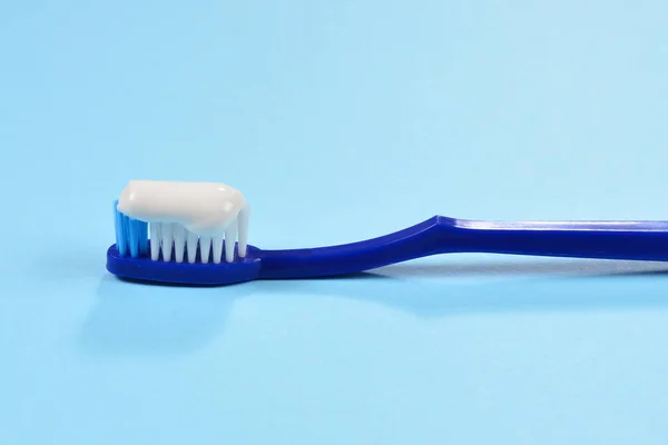 Toothbush a fogkrém a kék háttér. — Stock Fotó