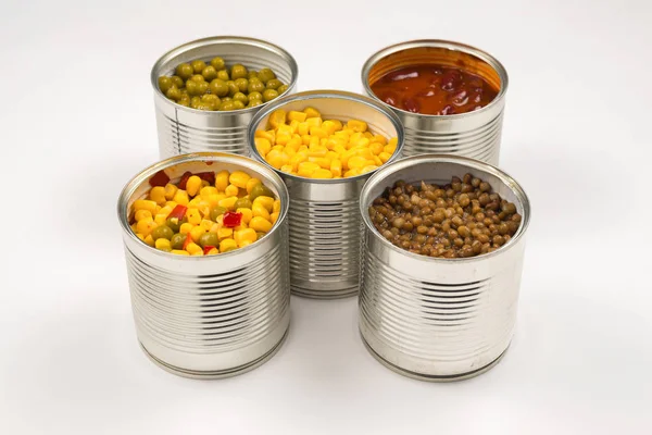 Beyaz arka planda konserve yiyecekler. Yeşil bezelye, fasulye, mısır, mercimek