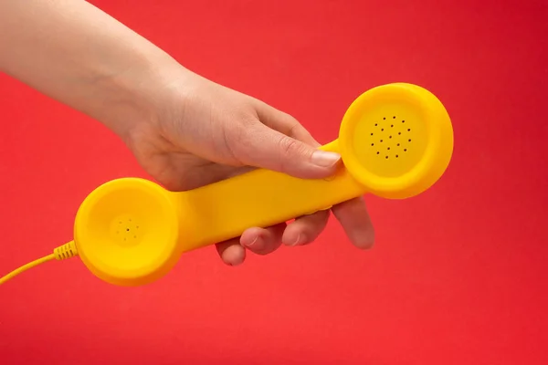 Auricular Amarillo Sobre Fondo Rojo Mano Mujer Copiar Espacio —  Fotos de Stock