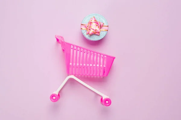 蓝色礼品盒 粉色背景的购物车上有粉色蝴蝶结 — 图库照片
