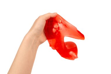 Beyaz ellerle izole edilmiş bir kadının elindeki kırmızı balçık oyuncağı. Üst görünüm. 