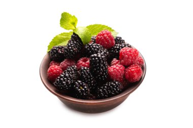 Ahududu, böğürtlen ve nane yaprağı seramik kahverengi kâsede beyaz arka planda izole edilmiş..  