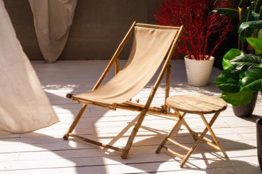 Rahat bambu koltuklar ve masa, açık havada bitkiler. Konfor bölgesi.