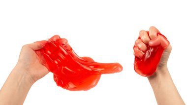 Beyaz ellerle izole edilmiş bir kadının elindeki kırmızı balçık oyuncağı. Üst görünüm. 