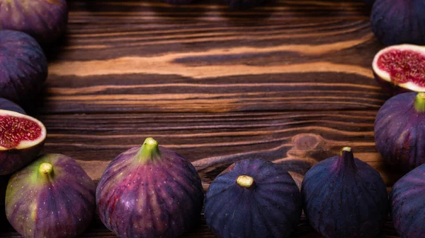 Ahşap arka planda bir kasede lezzetli incirler. Üst Manzara. Dilimler.  