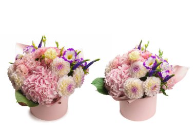 Beyaz arka planda izole edilmiş pembe bir kutuda pembe ve mor çiçek demeti.. 