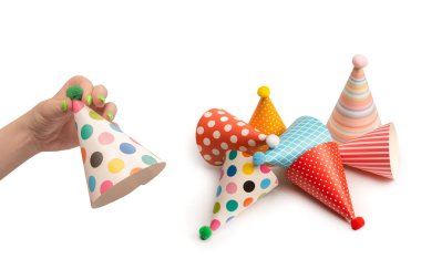 Beyaz arka planda izole edilmiş kadınların ellerinde renkli bir doğum günü şapkası.