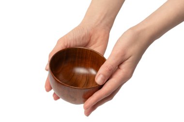 Kadın eli beyaz arka planda izole edilmiş ahşap bir kase tutuyor.. 