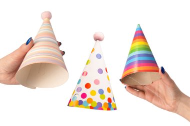 Beyaz arka planda izole edilmiş kadınların ellerinde renkli bir doğum günü şapkası..