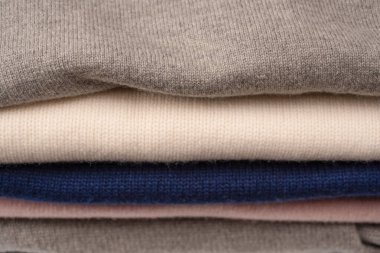 Beyaz arka planda izole edilmiş bir grup kalın kazak. Beyaz arkaplanda katlanmış süveter yığını.