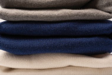 Beyaz arka planda izole edilmiş bir grup kalın kazak. Beyaz arkaplanda katlanmış süveter yığını.