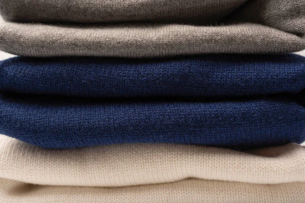 Beyaz arka planda izole edilmiş bir grup kalın kazak. Beyaz arkaplanda katlanmış süveter yığını.