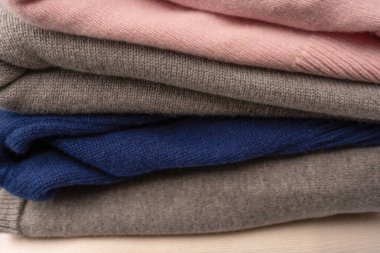 Beyaz arka planda izole edilmiş bir grup kalın kazak. Beyaz arkaplanda katlanmış süveter yığını.