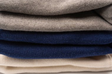 Beyaz arka planda izole edilmiş bir grup kalın kazak. Beyaz arkaplanda katlanmış süveter yığını.