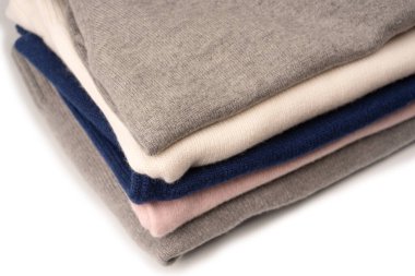 Beyaz arka planda izole edilmiş bir grup kalın kazak. Beyaz arkaplanda katlanmış süveter yığını.