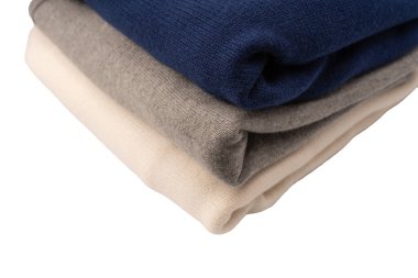 Beyaz arka planda izole edilmiş bir grup kalın kazak. Beyaz arkaplanda katlanmış süveter yığını.