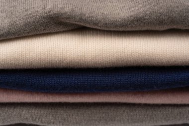 Beyaz arka planda izole edilmiş bir grup kalın kazak. Beyaz arkaplanda katlanmış süveter yığını.