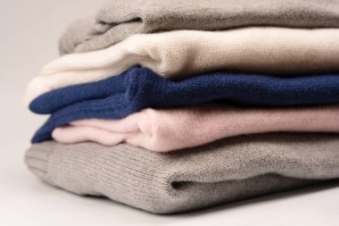 Beyaz arka planda izole edilmiş bir grup kalın kazak. Beyaz arkaplanda katlanmış süveter yığını.