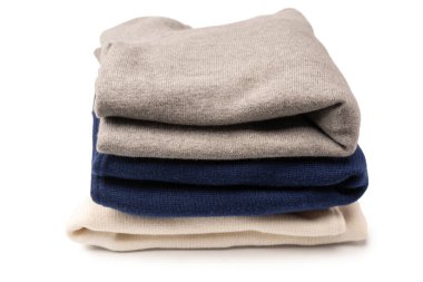 Beyaz arka planda izole edilmiş bir grup kalın kazak. Beyaz arkaplanda katlanmış süveter yığını.