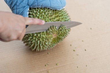 Dikenler bir yeri vardır durian Kabuk soymak için bıçak kullanarak ele