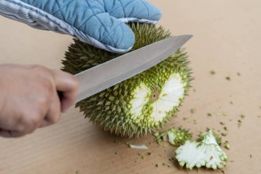 Dikenler bir yeri vardır durian Kabuk soymak için bıçak kullanarak ele