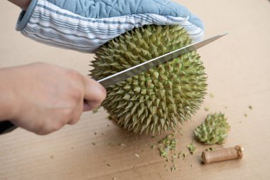 Dikenler bir yeri vardır durian Kabuk soymak için bıçak kullanarak ele
