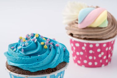 Beyaz arka plan üzerinde izole lezzetli renkli cupcake yakın çekim.