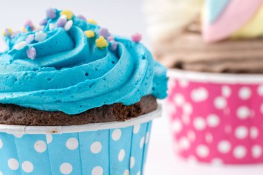 Beyaz arka plan üzerinde izole lezzetli renkli cupcake yakın çekim.