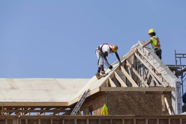 İşçiler inşaatta çatı üzerinde çalışıyorlar