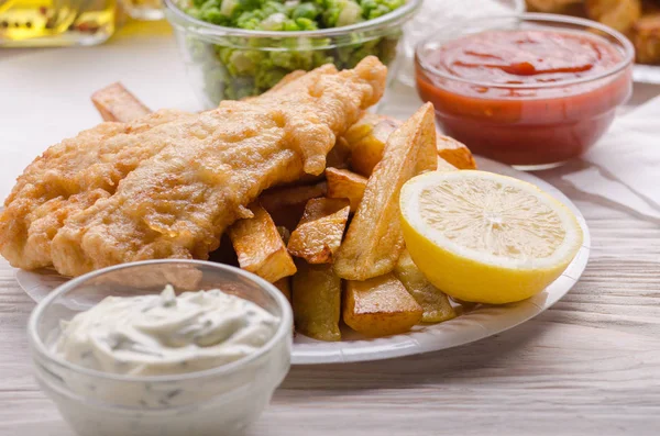 Traditional British street food fish and chips with ketchup and