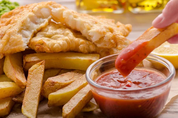 Traditional British street food fish and chips with ketchup sauc