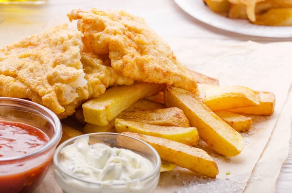 Traditional British street food fish and chips with ketchup and