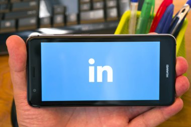Piatra Neamt, Romanya - 30 Temmuz 2018: El bir cep telefonu ile LinkedIn logo üstünde belgili tanımlık perde, office arka plan tutar.