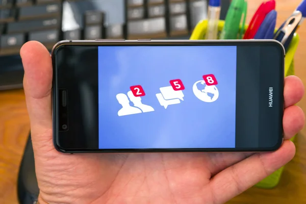 罗马尼亚的 Piatra Neamt 2018年7月30日 Hand 手持手机 屏幕上有 Facebook 通知图标 办公室背景 — 图库照片