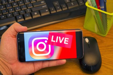 Piatra Neamt, Romanya - 30 Temmuz 2018: El Samsung S8 + Instagram Live logolu tutan üstünde belgili tanımlık perde, office arka plan.