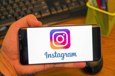 Piatra Neamt, Romanya - 30 Temmuz 2018: El Samsung S8 + Instagram logolu tutan üstünde belgili tanımlık perde, office arka plan.