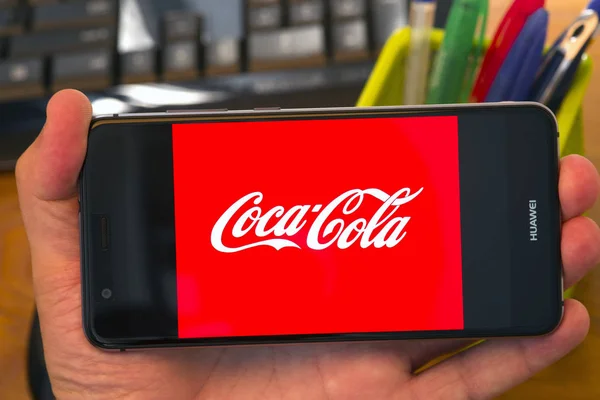 罗马尼亚皮亚特拉 内姆特 2018年7月30日 手拿着屏幕上有可口可乐标志的手机 办公室背景 — 图库照片