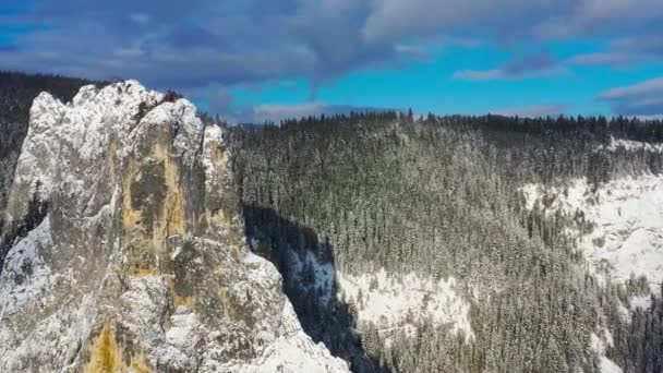 Летающий дрон рядом с огромной скалой зимой — стоковое видео