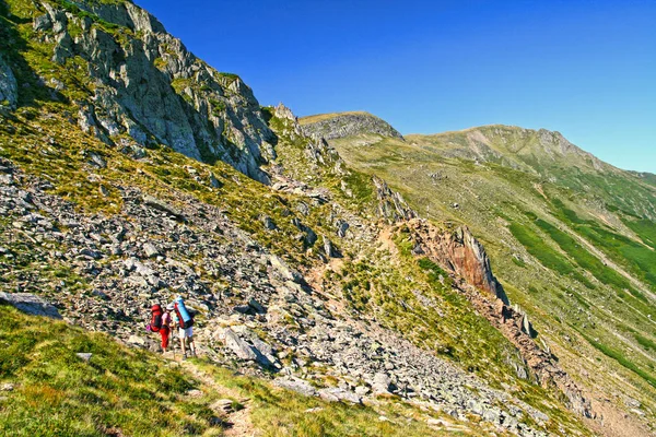 Sommar berg scen, vandring turister på Trail. — Stockfoto