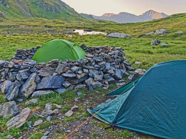 Alpine tents in a green mountain landscape