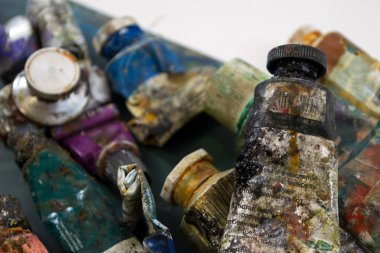 Bir tüp kirli bir palette parlak yağlı boya. Kullanılan boyalar.