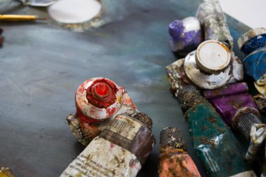 Bir tüp kirli bir palette parlak yağlı boya. Kullanılan boyalar.