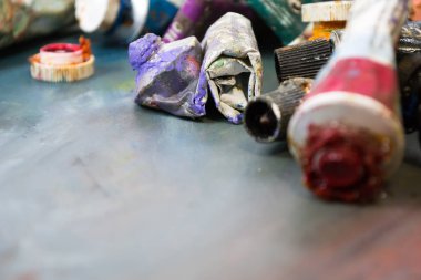 Bir tüp kirli bir palette parlak yağlı boya. Kullanılan boyalar.