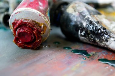 Bir tüp kirli bir palette parlak yağlı boya. Kullanılan boyalar.