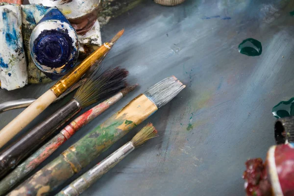Bir tüp kirli bir palette parlak yağlı boya. Kullanılan boyalar.