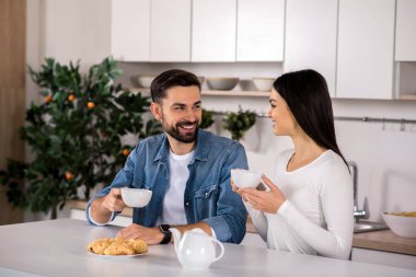 Teaparty. Mutfakta, oturma ve ev yapımı hamur işleri ile çay içme neşeli güzel çift