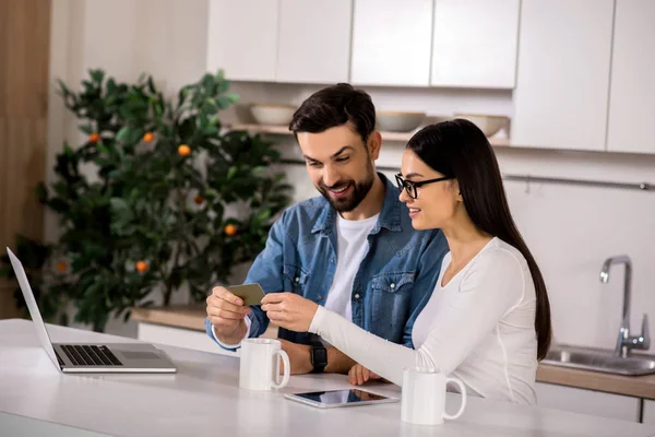 Finanzas Línea Alegre Joven Pareja Sentada Cocina Mientras Sostiene Tarjeta — Foto de Stock