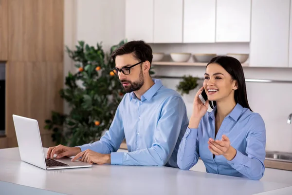 Positive life. Cheerful businesswoman talking on phone while her colleague using laptop