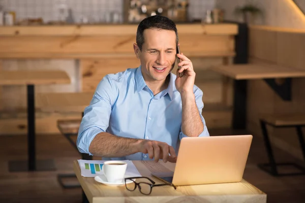 Усміхнений Бізнесмен Працює Ноутбуці Кафе Під Час Розмови Смартфоні — стокове фото